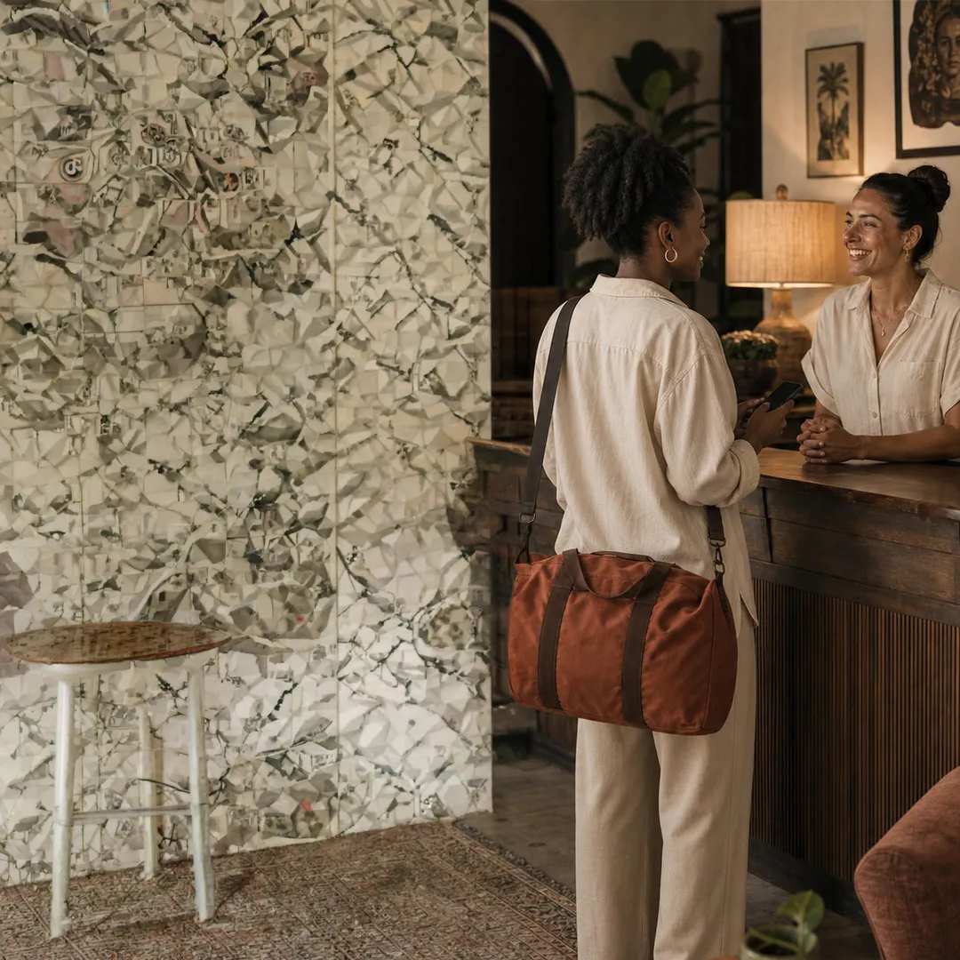A guest checking in at a warm boutique hotel reception